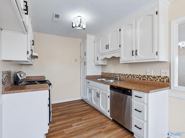 kitchen featuring sink, white cabinetry, stainless steel appliances, light hardwood / wood-style floors, and decorative backsplash