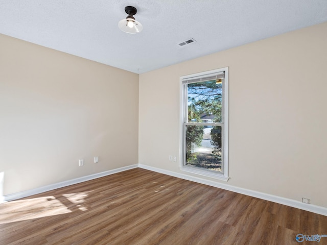 empty room featuring hardwood / wood-style floors and a textured ceiling