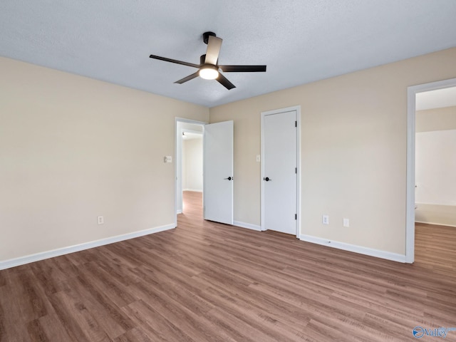 unfurnished bedroom featuring ceiling fan, a textured ceiling, and light wood-type flooring