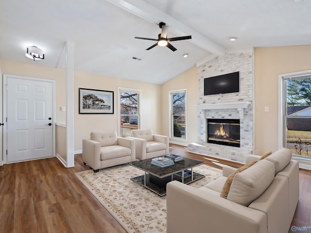 living room featuring wood-type flooring, vaulted ceiling with beams, ceiling fan, and a fireplace