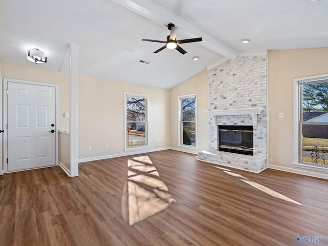 unfurnished living room with lofted ceiling with beams, a textured ceiling, dark hardwood / wood-style flooring, ceiling fan, and a fireplace