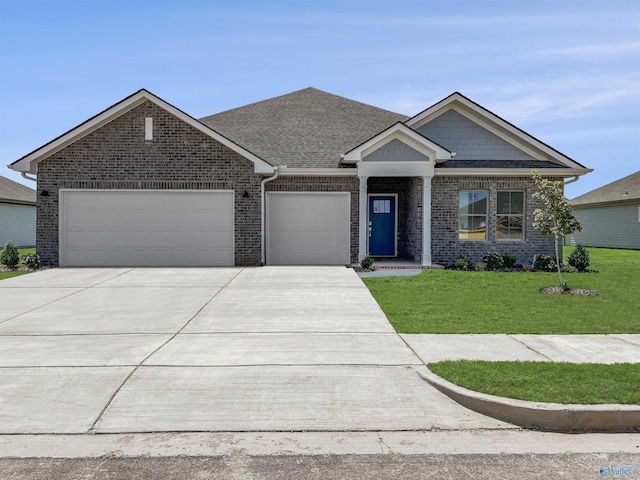 view of front of home featuring a front yard, an attached garage, and brick siding