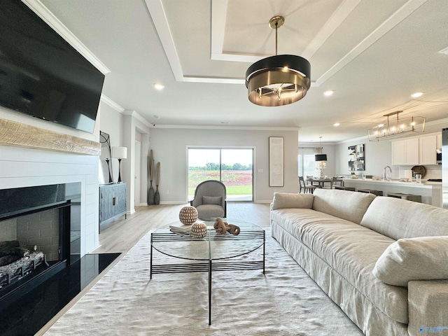 living area with ornamental molding, recessed lighting, light wood-style floors, a fireplace, and baseboards