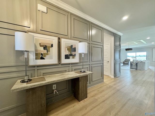 office featuring a decorative wall, recessed lighting, light wood-style floors, and ornamental molding