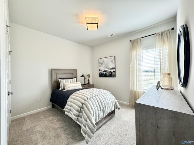 bedroom with visible vents, baseboards, and light colored carpet