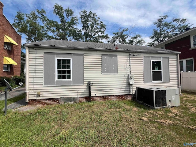 back of house featuring central AC and a yard