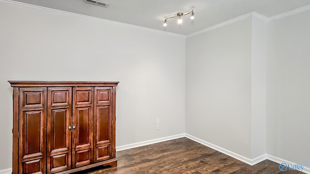 unfurnished room featuring dark wood-style floors, ornamental molding, visible vents, and baseboards