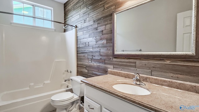 bathroom featuring toilet, wood walls, vanity, and shower / bathtub combination