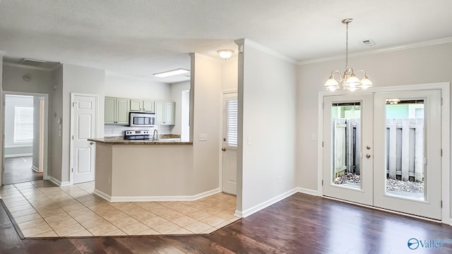 kitchen featuring pendant lighting, stainless steel appliances, a peninsula, dark countertops, and green cabinetry