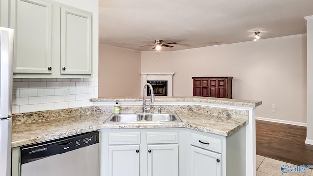 kitchen featuring dishwasher, light countertops, a peninsula, and a sink