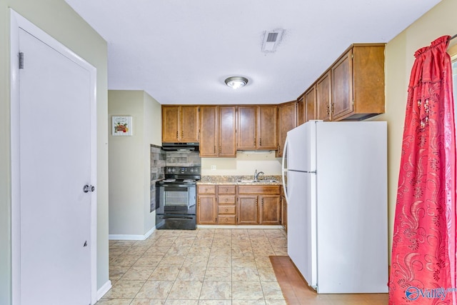3104 Sandlin Rd SW, Decatur, AL 35603 - kitchen with black electric range, freestanding refrigerator, light countertops, a sink, and under cabinet range hood