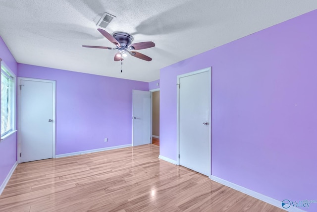 3104 Sandlin Rd SW, Decatur, AL 35603 - unfurnished bedroom featuring wood finished floors, a textured ceiling, baseboards, and ceiling fan