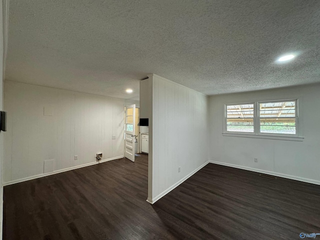 unfurnished room with dark hardwood / wood-style floors and a textured ceiling