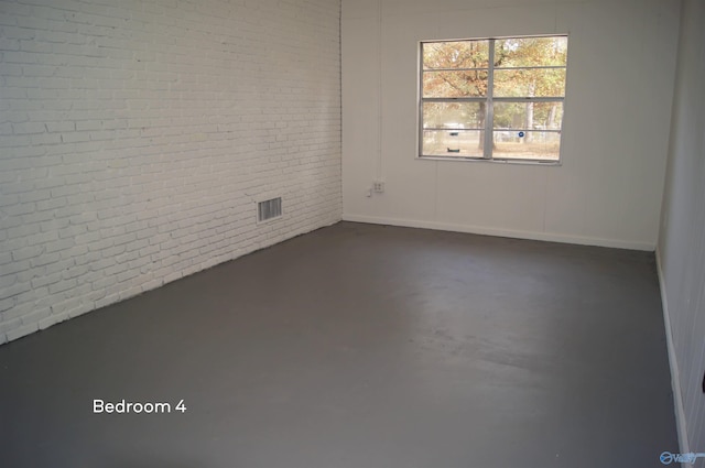 empty room featuring brick wall