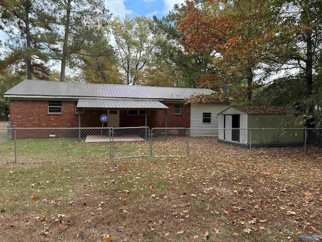 rear view of house featuring a storage shed