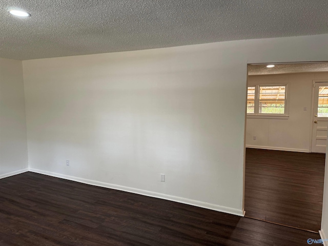 empty room featuring dark hardwood / wood-style flooring and a textured ceiling