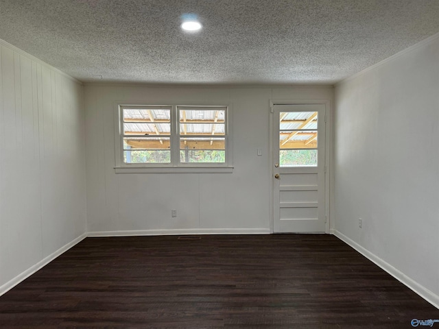 empty room featuring dark hardwood / wood-style floors and a textured ceiling