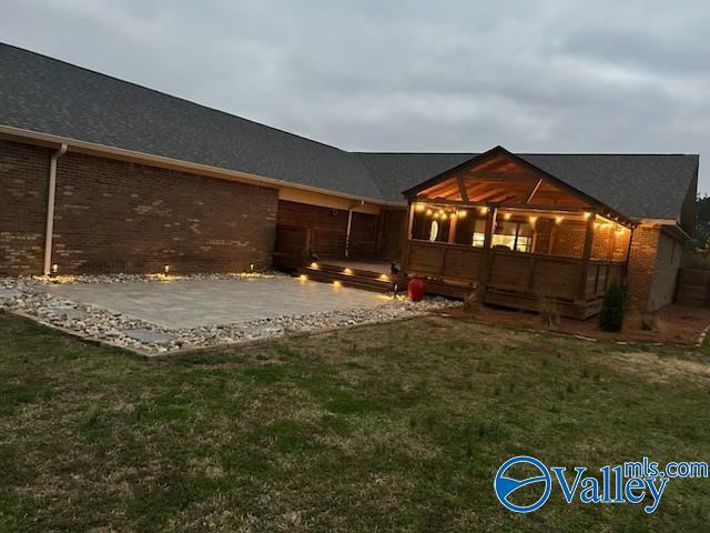 rear view of house featuring a yard and a patio area