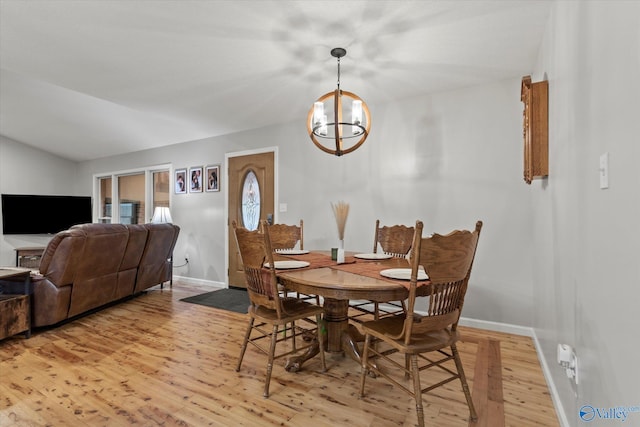 dining room with light hardwood / wood-style floors and a chandelier