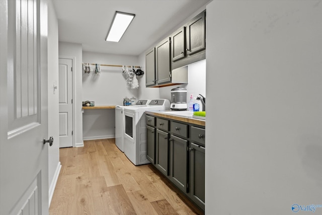 laundry room with light wood-type flooring, cabinets, sink, and independent washer and dryer