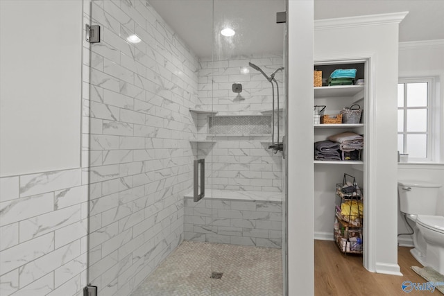 bathroom featuring an enclosed shower, toilet, hardwood / wood-style flooring, and crown molding