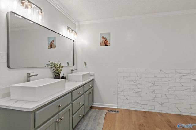 bathroom with ornamental molding, vanity, and hardwood / wood-style floors