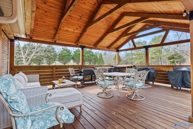 sunroom featuring a wealth of natural light, vaulted ceiling with beams, and wooden ceiling