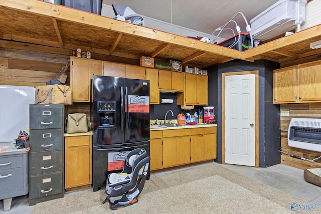 kitchen featuring heating unit, black refrigerator with ice dispenser, and sink