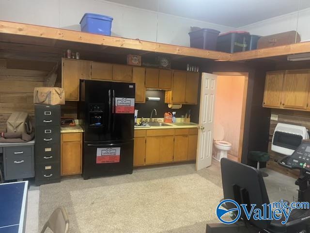 kitchen with sink and black refrigerator with ice dispenser