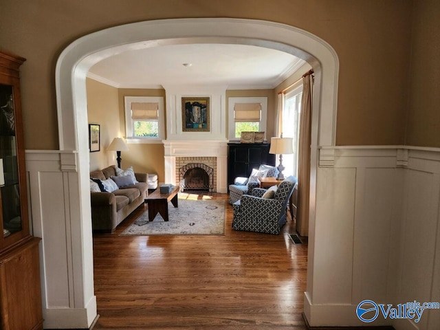 interior space featuring a brick fireplace, crown molding, and hardwood / wood-style flooring