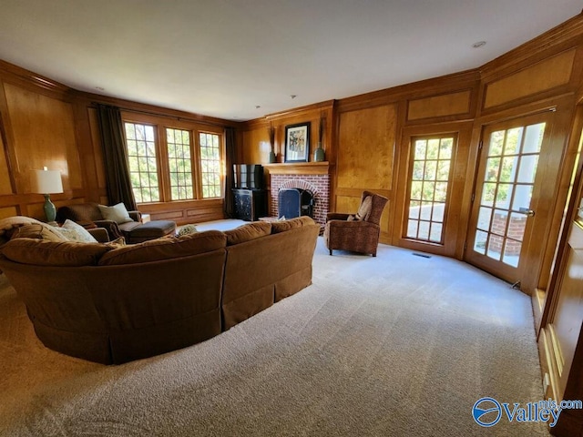 carpeted living room with a brick fireplace and wood walls