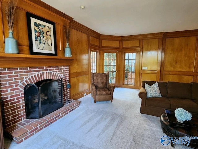 carpeted living room with a fireplace and wooden walls