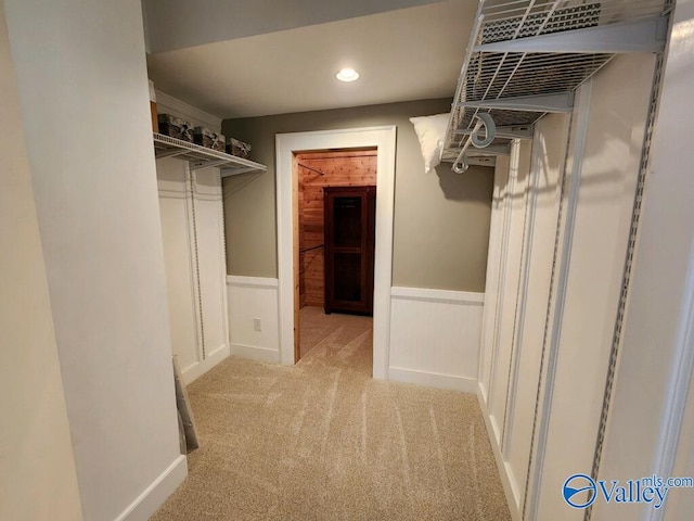 walk in closet featuring light carpet