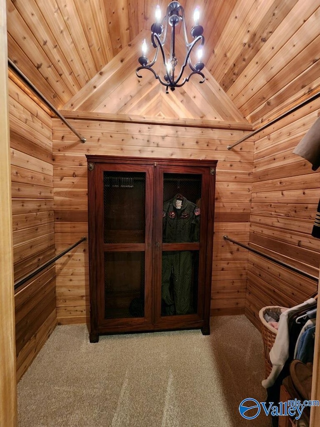 interior space with carpet floors, wooden walls, wooden ceiling, and an inviting chandelier