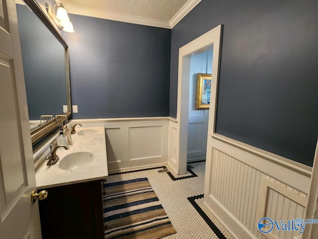 bathroom featuring ornamental molding, vanity, and a textured ceiling