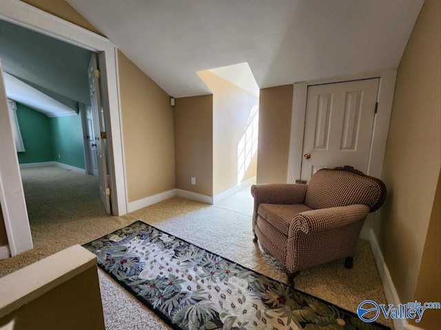 sitting room featuring vaulted ceiling and carpet flooring