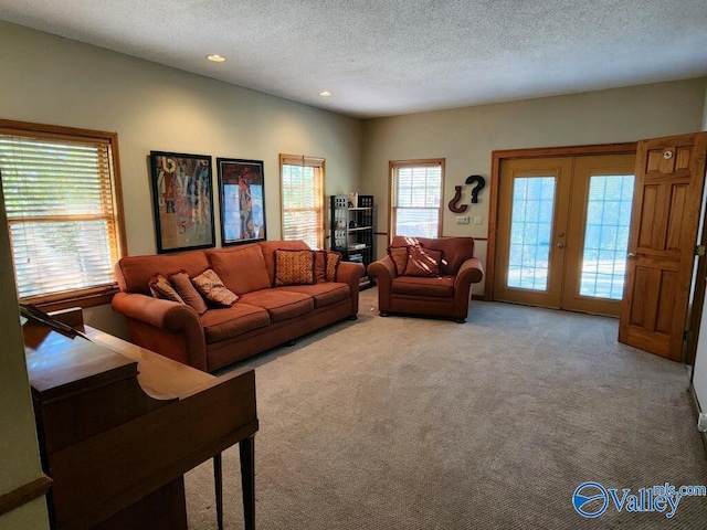 living room with light colored carpet, a textured ceiling, and french doors