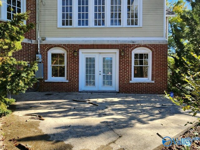 view of exterior entry with a patio and french doors