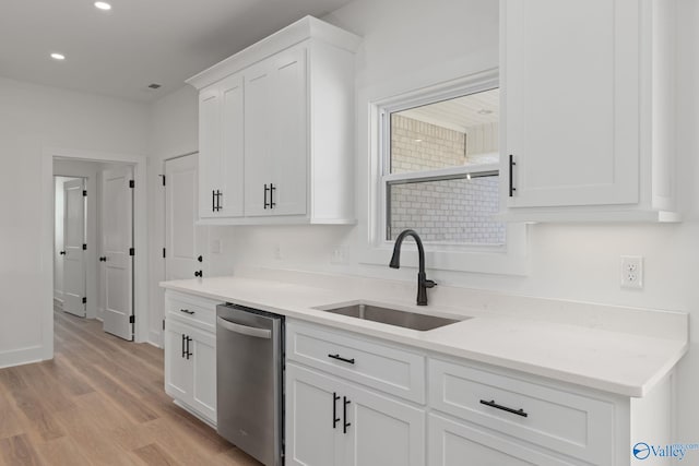 kitchen with stainless steel dishwasher, a sink, light wood-style floors, recessed lighting, and white cabinetry