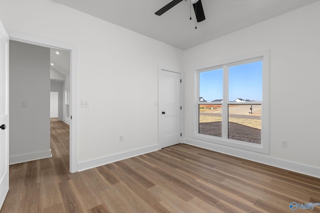 empty room with baseboards, recessed lighting, ceiling fan, and wood finished floors