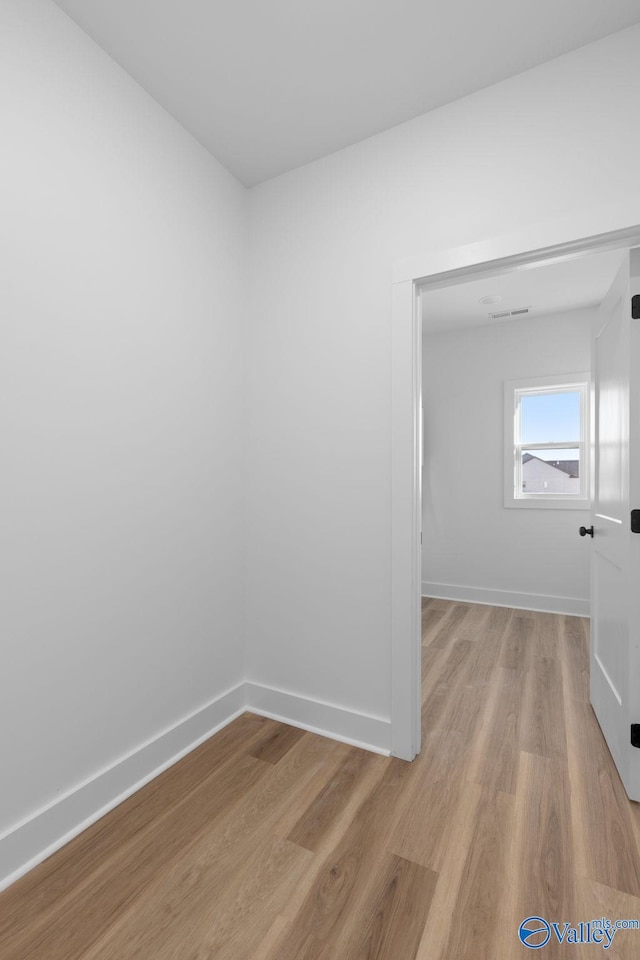 empty room featuring baseboards and light wood-type flooring
