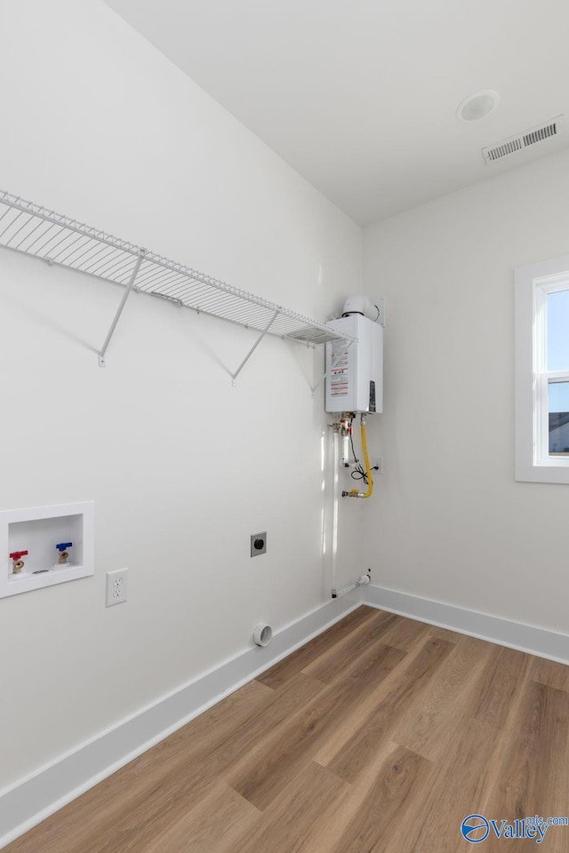 washroom featuring washer hookup, hookup for an electric dryer, laundry area, visible vents, and light wood-style floors
