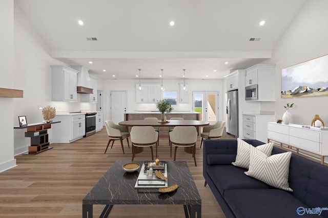 living area with light wood-style floors, recessed lighting, and visible vents