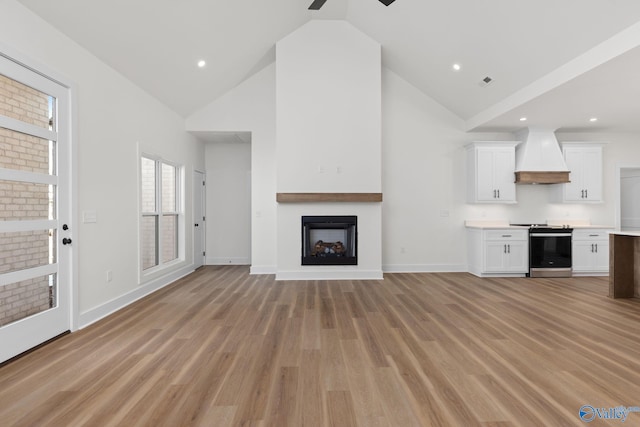 unfurnished living room featuring a fireplace, baseboards, high vaulted ceiling, a ceiling fan, and light wood-style flooring