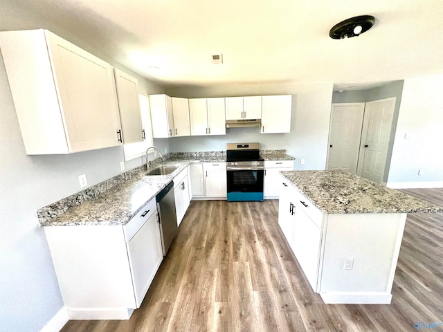 kitchen with a center island, white cabinets, sink, light hardwood / wood-style flooring, and appliances with stainless steel finishes