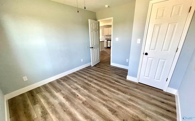 unfurnished bedroom with dark hardwood / wood-style floors