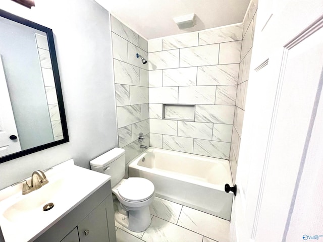 full bathroom featuring vanity, tiled shower / bath combo, and toilet