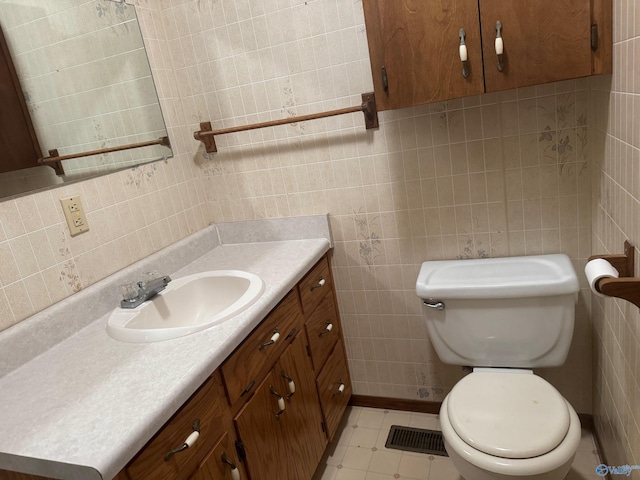 bathroom featuring vanity, tile walls, and toilet