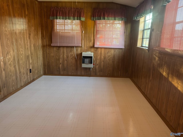 spare room featuring wooden walls and heating unit