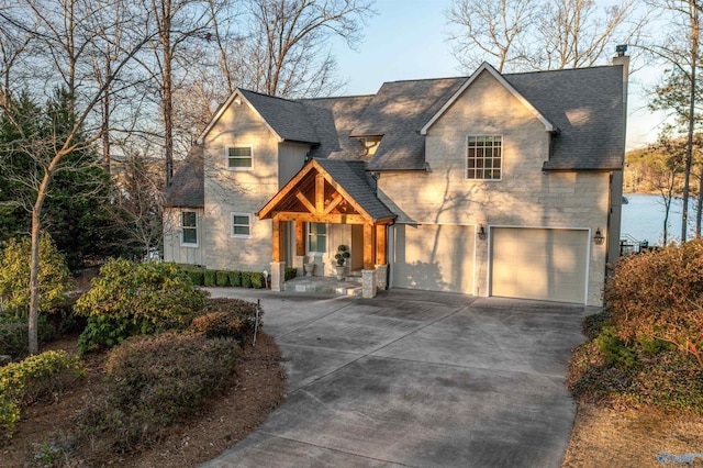 view of front of property with board and batten siding, stone siding, driveway, and a chimney